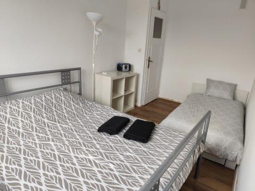 a bedroom with a bed with two black towels on it at Maison 3 chambres Le Mans, proche circuit in Le Mans