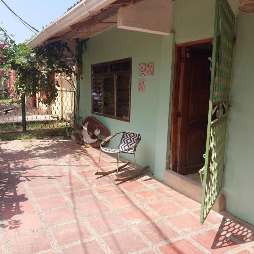 a chair sitting on the porch of a house at Hostel Nugeku in Rincón