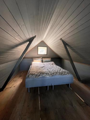a bed in a small room with a ceiling at Villa Vannes in Skånevik