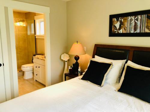 a bedroom with a bed and a bathroom with a toilet at Qualicum Landing Seaside Vill in Qualicum Beach