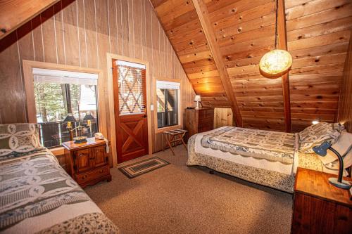 a bedroom with two beds in a log cabin at Das Berghaus By Hauserman Rentals in Tahoe City