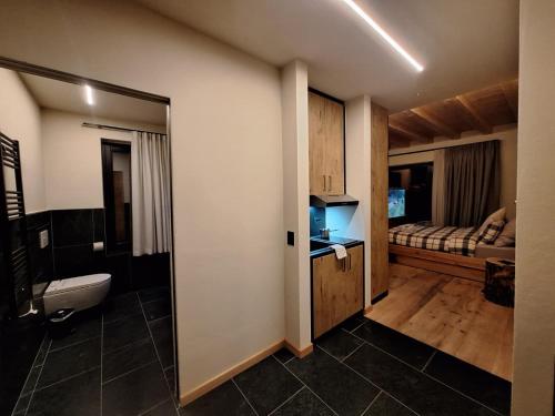 a bathroom with a toilet and a bed in a room at Green Hospitality Monolocale Stella Alpina in Livigno
