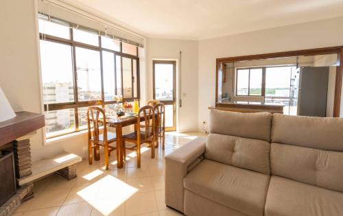 ein Wohnzimmer mit Sofa und Tisch in der Unterkunft Amorosa Beach Rooftop - 400 metros da Praia in Viana do Castelo