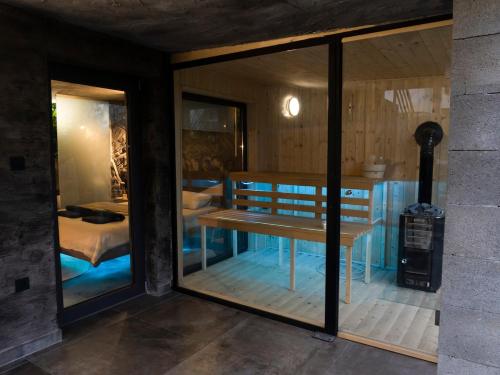a room with a bench in a room with windows at Forest Whisper by GoldenPinpoint in Leštakovec