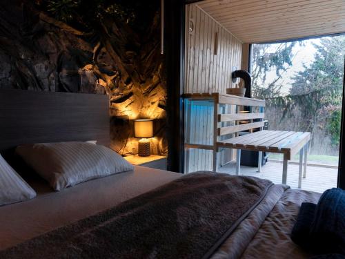 a bedroom with a bed and a bench next to a window at Forest Whisper by GoldenPinpoint in Leštakovec