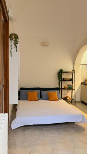 a large bed with two orange pillows in a room at Lumia - Casa Vacanze in Martina Franca