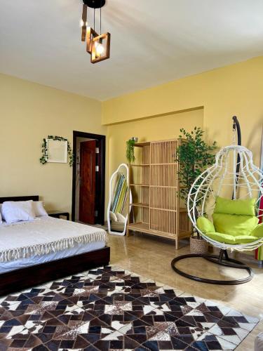 a bedroom with a bed and a chair at Yousrys Nest Cozy Rooftop Studio in New cairo