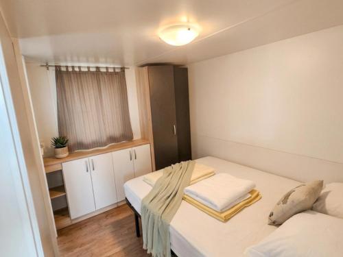 a small room with two beds and a window at Mobile Homes Peroš in Zaton