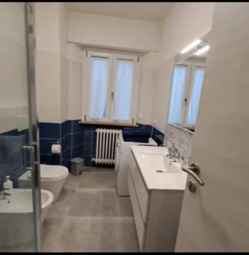 a bathroom with two sinks and a toilet and a mirror at Casa Margherita in Castelfidardo