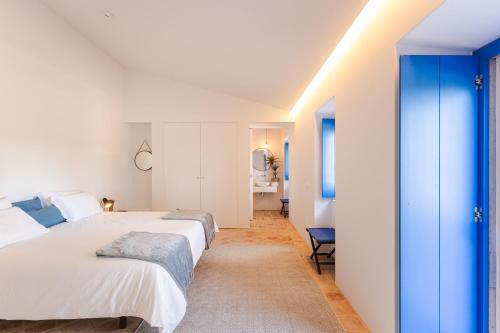 a bedroom with two beds and a bathroom at Monte da Torre in Tavira
