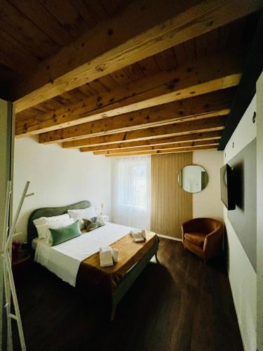 a bedroom with a large bed and a wooden ceiling at A Casa di Angelica in Piovene Rocchette
