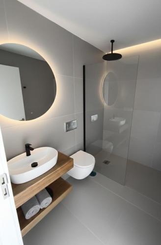a bathroom with a sink and a toilet and a mirror at Apartamentos Arinaga Ocean View in Arinaga