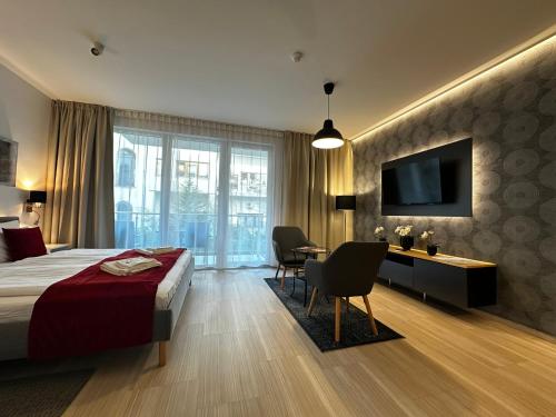 a hotel room with a bed and a desk and a television at B40 Green ApartRooms in Budapest