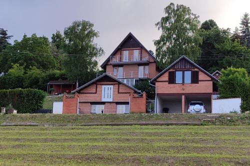 a large house with a grass field in front of it at House 33 in Stari Slankamen