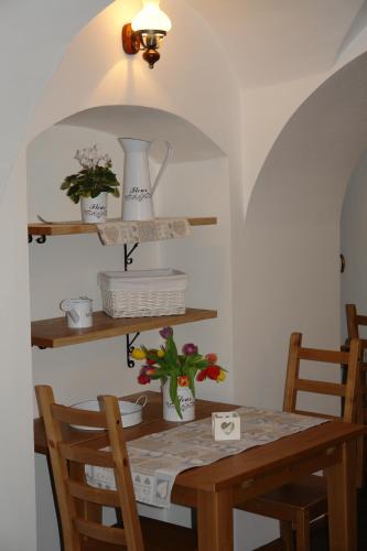a dining room table with two chairs and a table with flowers at Hotel Střelnice in Teplice nad Metují