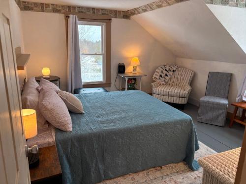 a bedroom with a bed and a chair and a window at My Valhalla Farm in Oakland