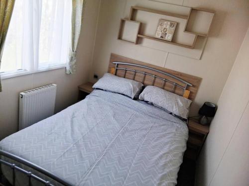 a bed in a small room with a window at My Spacious Kentish 3-Room Van in Birchington