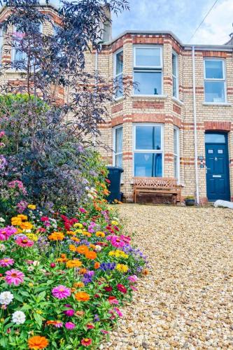 a house with a garden of flowers in front of it at Ocean Terrace, Ilfracombe, 4 bedrooms, Sleeps 8, Stunning Sea Views, Parking, Garden, Pet Friendly in Ilfracombe