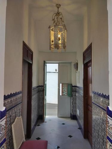 a hallway with a chandelier and a door to a room at Casa MaCló Tranquilidad y autenticidad in Máguez