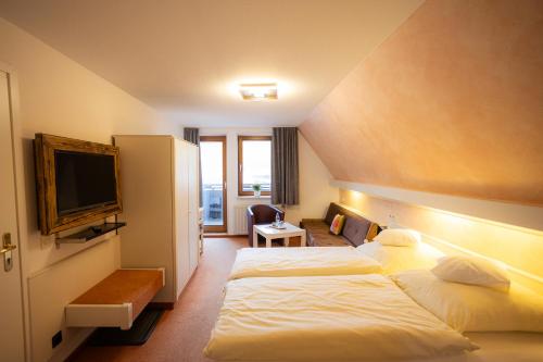 a hotel room with two beds and a television at Hotel Bischof in Schmallenberg