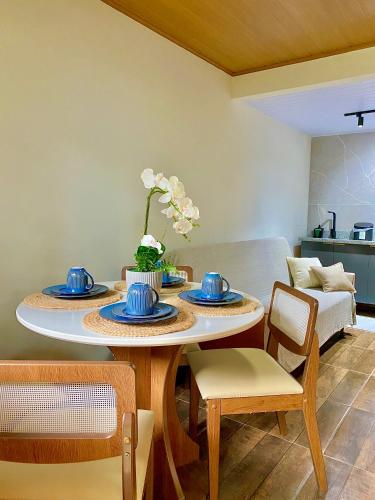 a dining room with a table with blue dishes on it at Chalé Shanti in Resende