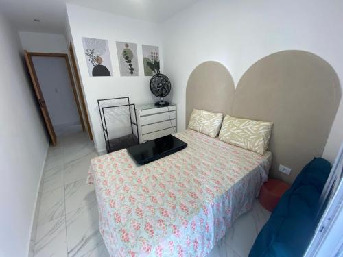 a bedroom with a bed with a large headboard at Atlântico 34 Guilhermina in Praia Grande
