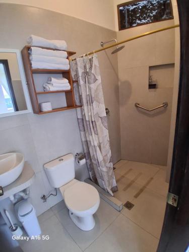a bathroom with a toilet and a sink and a shower at Barrio Central in Puerto Ayora