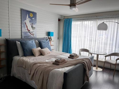 a bedroom with a bed and a table and a window at Boutique hotel Zeelui in Egmond aan Zee