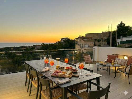 a table with food and wine glasses on a balcony at Les Flors de Cunit Villa Edelweiss in Cunit
