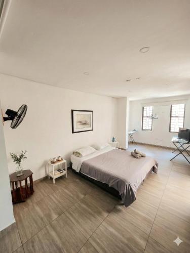 a bedroom with a large bed in a white room at Pilarica Gardens in Medellín