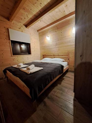 a bedroom with a bed in a wooden cabin at Straza in Rožanstvo