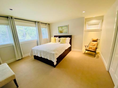 a bedroom with a bed and a chair in it at Qualicum Landing Paradise in Qualicum Beach