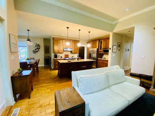 a living room with a white couch and a kitchen at Qualicum Landing Paradise in Qualicum Beach