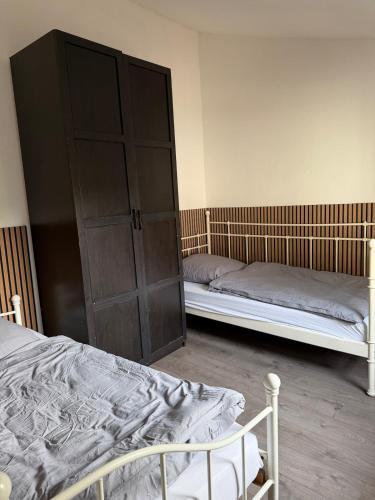 a bedroom with two beds and a large cabinet at Arcadia in Remagen