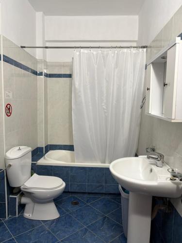 une salle de bains avec toilettes, lavabo et douche dans l'établissement Blanche appartement, à Saranda