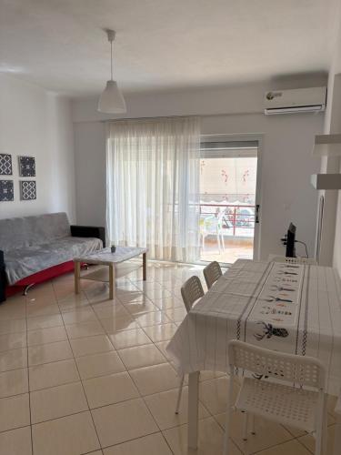 un salon avec un canapé, une table et des chaises dans l'établissement Blanche appartement, à Saranda