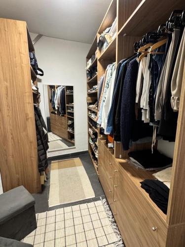 a walk in closet with wooden cabinets and a mirror at Full casa 1 in Cosenza
