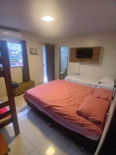 a bedroom with a bed with an orange sheet at Pousada JC 50 in Santarém