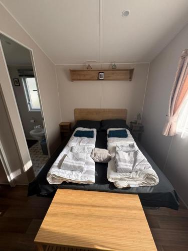 a bedroom with a bed with two pillows on it at Chalet Meerwijck mit Terrasse am Wasser und Meer mit Schwimmbad in Kropswolde