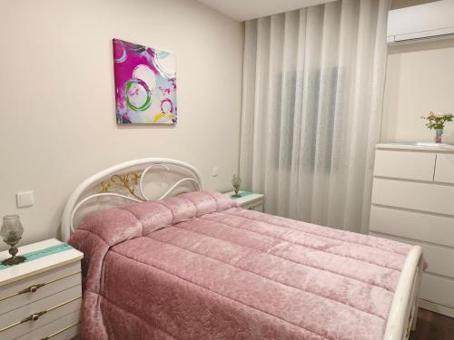 a bedroom with a pink bed with a pink blanket at Casa Valinhas in São Jorge