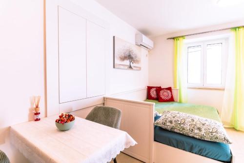 a small room with a table and a bed at Studio apartman Relota in Kaštela