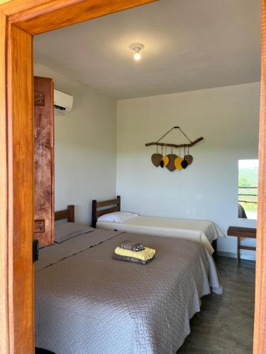 a bedroom with two beds and a window at Quintal de minas Pousada in Delfinópolis