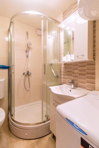 a bathroom with a shower and a toilet and a sink at Studio apartman Relota in Kaštela
