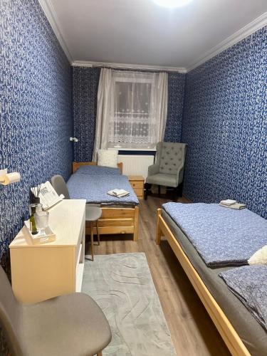 a bedroom with two beds and a desk and a chair at Restaurace a penzion u Kulíků in Raspenava