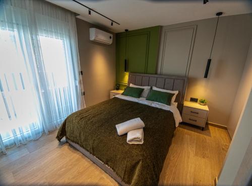 a bedroom with a large bed with two towels on it at Olive Home in Alexandroupoli