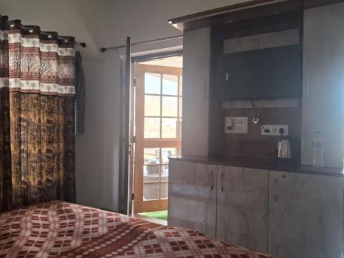 a bedroom with a bed and a large window at Nilkanth gest hause in Mukteshwar