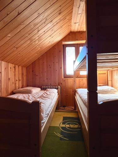 a room with two beds in a wooden cabin at brown bear lodge in Žabljak