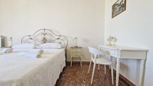 a bedroom with a white bed and a desk at Pabula Vernatica Salento in San Pietro Vernotico