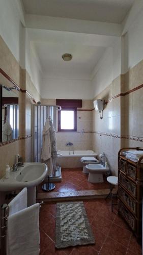 a bathroom with two sinks and a tub and two toilets at Pabula Vernatica Salento in San Pietro Vernotico