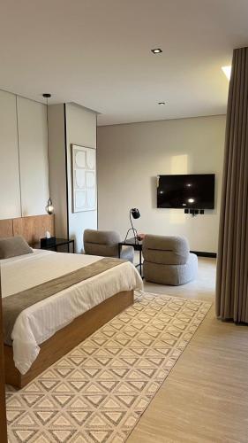 a bedroom with a large bed and a flat screen tv at اصيلة فيلا Asilah Villa in Buraydah